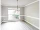 Elegant dining room featuring gray walls, white trim, a modern chandelier, and hardwood floors at 4820 Camden Sw Dr, Conyers, GA 30094