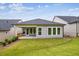 View of a well-manicured backyard with a covered porch, large windows, and green grass at 5133 Aster Bnd, Canton, GA 30114