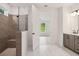 Modern bathroom showcases a glass-enclosed shower, a double vanity, and an entrance to the light-filled bedroom at 5133 Aster Bnd, Canton, GA 30114