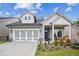 Charming home featuring a welcoming front porch, two-car garage, and beautiful landscaping at 5133 Aster Bnd, Canton, GA 30114