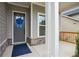 Inviting front entrance with a blue ribbon, stone accents, and a covered porch area at 5133 Aster Bnd, Canton, GA 30114
