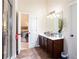 Bathroom with cherry vanity, tiled floors, and an open doorway into the adjacent bedroom at 5715 Keys Way, Lithonia, GA 30058