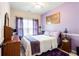 Cozy bedroom with purple walls, ceiling fan, and a comfortable bed dressed in white and purple linens at 5715 Keys Way, Lithonia, GA 30058