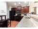Modern kitchen featuring dark wood cabinets, granite countertops, and stainless steel appliances at 5715 Keys Way, Lithonia, GA 30058