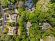 Aerial view of wooded community and homes with mature trees, circular drives, and private backyard pools at 302 Rolling Rock Se Rd, Marietta, GA 30067