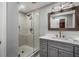 Bathroom featuring tiled walk-in shower and gray vanity with a marble countertop and modern fixtures at 302 Rolling Rock Se Rd, Marietta, GA 30067