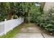 Landscaped backyard features a driveway, green plants and a white wooden fence at 3241 Adams St, Atlanta, GA 30337