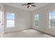 This bedroom has neutral carpet and paint with 3 big windows and a ceiling fan at 3241 Adams St, Atlanta, GA 30337