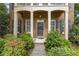Close-up of home's front door, flanked by lush landscaping and shuttered windows at 3241 Adams St, Atlanta, GA 30337