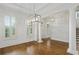Open-concept living area with hardwood floors, tall columns, and modern light fixtures at 3241 Adams St, Atlanta, GA 30337