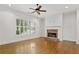 Bright living room with hardwood floors, brick fireplace, large window with plantation shutters, and a ceiling fan at 3241 Adams St, Atlanta, GA 30337