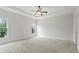 Spacious main bedroom with neutral carpet, tray ceiling, ceiling fan, and well-lit with large windows at 3241 Adams St, Atlanta, GA 30337
