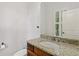 Classic powder room with a granite countertop, wood cabinets, and a large mirror at 3241 Adams St, Atlanta, GA 30337