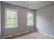 Carpeted bedroom with two windows and neutral paint, offering ample natural light at 5254 Greenpoint Dr, Stone Mountain, GA 30088