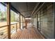 Long covered front porch featuring wood flooring and railing surrounding the entire length at 5254 Greenpoint Dr, Stone Mountain, GA 30088