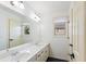 Bathroom with double sinks, large mirror, and cream-colored cabinets and trim at 6025 Golf View Xing, Locust Grove, GA 30248