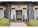 Welcoming front entrance featuring a glass-paned door, brick flooring, and elegant black columns, enhancing the curb appeal at 6025 Golf View Xing, Locust Grove, GA 30248