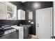 Well-organized laundry room featuring dark walls, modern washer and dryer, and ample storage cabinets at 6025 Golf View Xing, Locust Grove, GA 30248