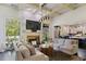 Bright living room with a coffered ceiling, stone fireplace, and large windows showcasing the exterior at 6025 Golf View Xing, Locust Grove, GA 30248