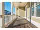 Covered porch with wooden flooring, white columns, and a view of the neighborhood at 1329 Booth Ave, Atlanta, GA 30318
