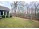 Spacious backyard featuring a well-maintained lawn, mature trees, and a wooden fence at 1344 Chipmunk Forest Chase, Powder Springs, GA 30127