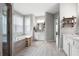 Spacious bathroom with tiled floor, soaking tub, shower, and white cabinetry with double vanity at 1344 Chipmunk Forest Chase, Powder Springs, GA 30127