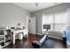 Bedroom featuring a desk, dark hardwood floors, a rowing machine, and plenty of natural light at 1344 Chipmunk Forest Chase, Powder Springs, GA 30127