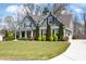 Charming two-story home boasts an inviting front porch and well-manicured front yard with mature landscaping at 1344 Chipmunk Forest Chase, Powder Springs, GA 30127