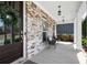 Close-up of the welcoming front porch with seating, a brick facade, and elegant lighting at 1344 Chipmunk Forest Chase, Powder Springs, GA 30127