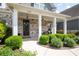Inviting front porch with stylish columns, brick accents, and manicured landscaping at 1344 Chipmunk Forest Chase, Powder Springs, GA 30127