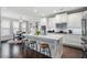 Modern kitchen featuring white cabinets, a large island with seating, and hardwood floors at 1344 Chipmunk Forest Chase, Powder Springs, GA 30127