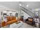 Open-concept living area with kitchen, hardwood floors, and a staircase at 1344 Chipmunk Forest Chase, Powder Springs, GA 30127