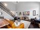 Spacious living room featuring a staircase, hardwood floors, and comfortable leather seating at 1344 Chipmunk Forest Chase, Powder Springs, GA 30127