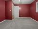 Empty bedroom with deep red walls, carpeted floors, and a bright window at 1899 Stratford Arms Dr, Morrow, GA 30260