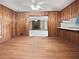 Open dining room featuring hardwood floors, wood paneled walls, and views into the living room at 1899 Stratford Arms Dr, Morrow, GA 30260