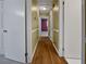 Hallway with wood floors and neutral paint leads to the bedrooms at 1899 Stratford Arms Dr, Morrow, GA 30260