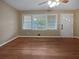 Empty living room with hardwood floors, large windows, and a ceiling fan at 1899 Stratford Arms Dr, Morrow, GA 30260