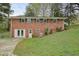 Brick home featuring a backyard with a small slope and mature trees, offering a partially shaded area at 281 Piedmont Ne Rd, Marietta, GA 30066