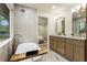 View of the bathroom which has double sinks, marble floors, a bathtub, a large window, and is next to the bedroom at 3805 Cloudland Se Dr, Smyrna, GA 30082