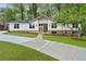 Charming home with updated front exterior, lush lawn, and a long concrete driveway at 3805 Cloudland Se Dr, Smyrna, GA 30082