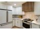 Kitchen boasts white cabinets, stainless appliances, granite countertops, and designer lighting at 3805 Cloudland Se Dr, Smyrna, GA 30082