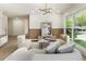 Airy living room with a modern chandelier, wood trim accent wall, and large windows showcasing yard at 3805 Cloudland Se Dr, Smyrna, GA 30082