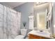 Well-lit bathroom featuring a modern sink, decorative mirror, toilet and marble print shower curtain at 4014 Ivy Trace Ln, Ellenwood, GA 30294