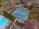 Aerial view of a tennis court, swimming pool, trees, and buildings at 2739 Springfount Trl, Lawrenceville, GA 30043