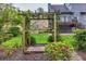 A decorative trellis creates an enchanting backyard with lush green grass and red azalea bushes at 2739 Springfount Trl, Lawrenceville, GA 30043