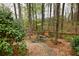 Serene backyard featuring a bench and stone pathway amidst mature trees, creating a tranquil outdoor space at 2739 Springfount Trl, Lawrenceville, GA 30043