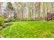 Large backyard with a well-maintained lawn, mature trees, and a staircase at 2739 Springfount Trl, Lawrenceville, GA 30043