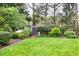 Well-manicured backyard with a storage shed surrounded by lush greenery and trees at 2739 Springfount Trl, Lawrenceville, GA 30043