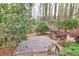 Stone patio amidst a wooded backyard with a low brick wall and lush plantings at 2739 Springfount Trl, Lawrenceville, GA 30043