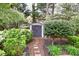 Backyard shed accessed by a stone path amidst manicured shrubs and lush plants at 2739 Springfount Trl, Lawrenceville, GA 30043
